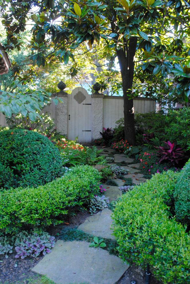 Foto på en liten vintage trädgård i skuggan längs med huset på våren, med naturstensplattor