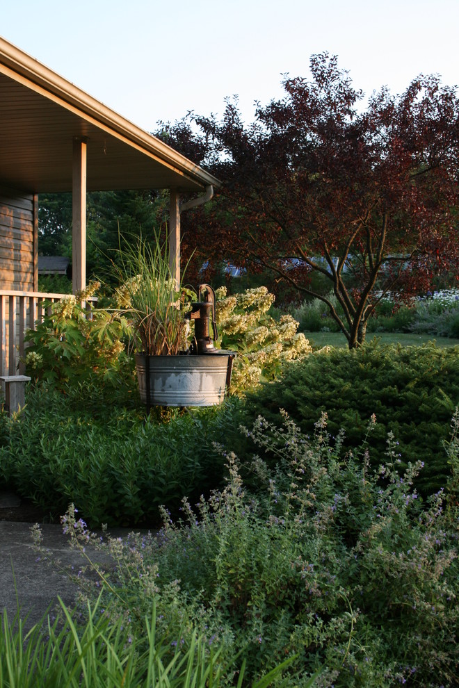 На фото: садовый фонтан на заднем дворе в классическом стиле с