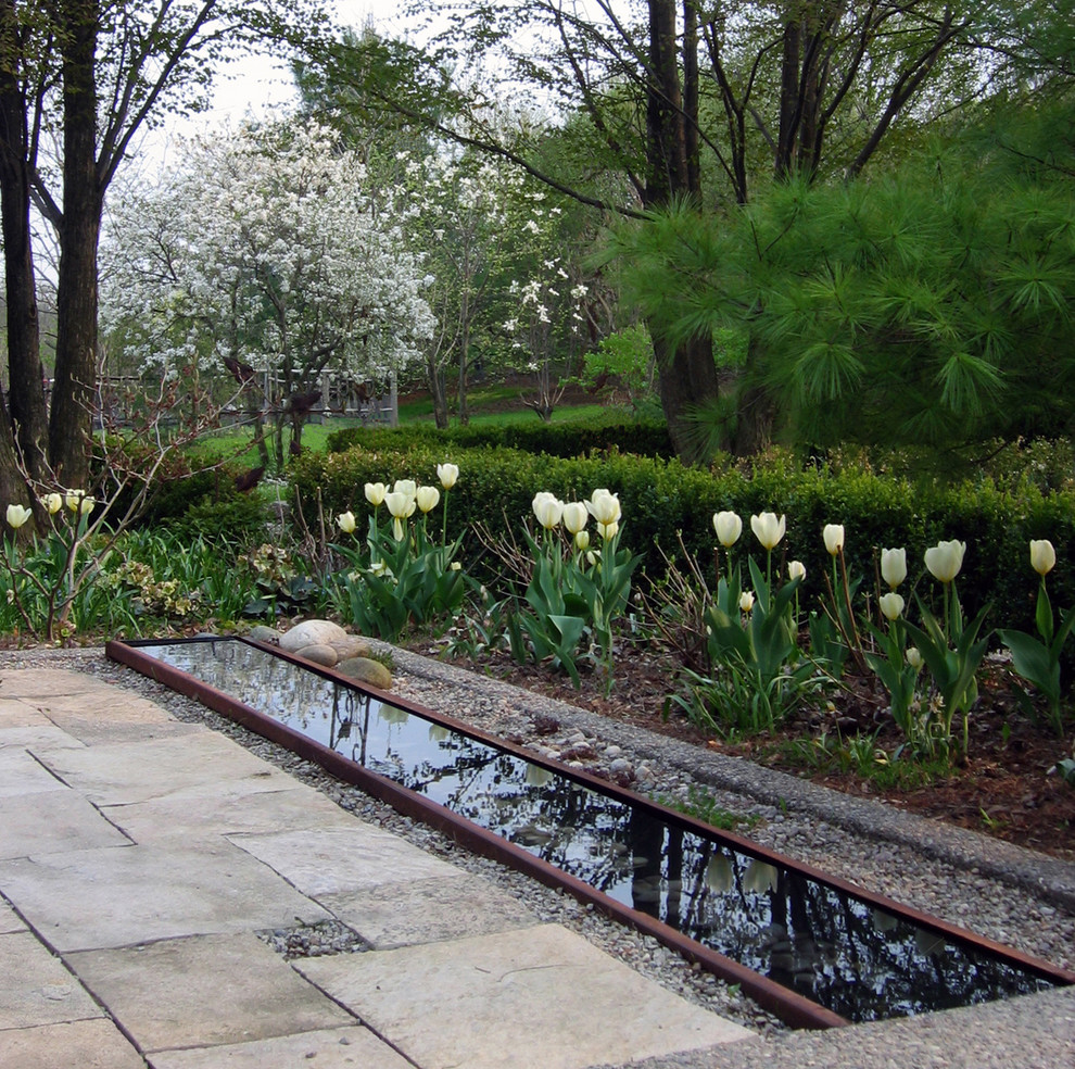 This is an example of a classic garden in Toronto with a water feature and natural stone paving.