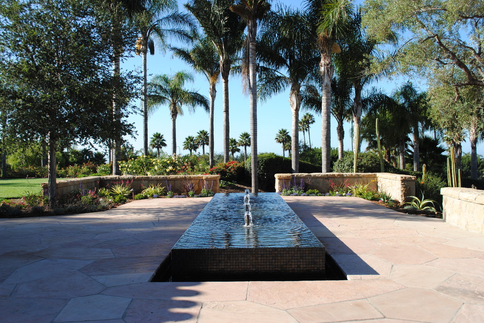 Großer Klassischer Garten hinter dem Haus mit Wasserspiel und Natursteinplatten in Santa Barbara