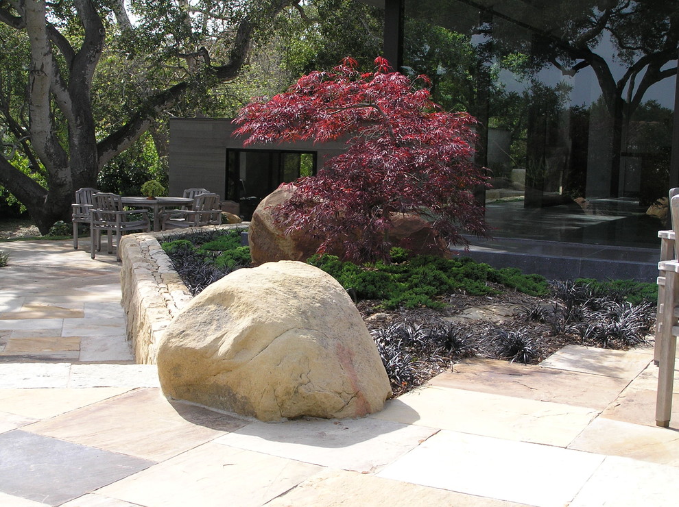 На фото: большой участок и сад на заднем дворе в стиле модернизм с покрытием из каменной брусчатки и камнем в ландшафтном дизайне