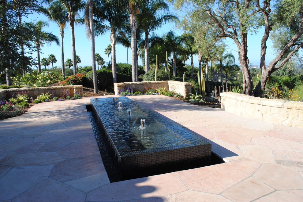 Großer Klassischer Garten hinter dem Haus mit Wasserspiel und Natursteinplatten in Santa Barbara