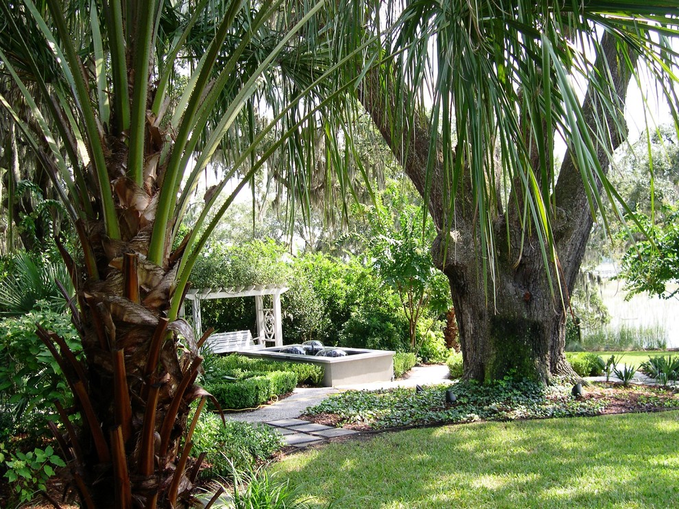 Foto de jardín actual grande en verano en patio trasero con fuente y adoquines de piedra natural