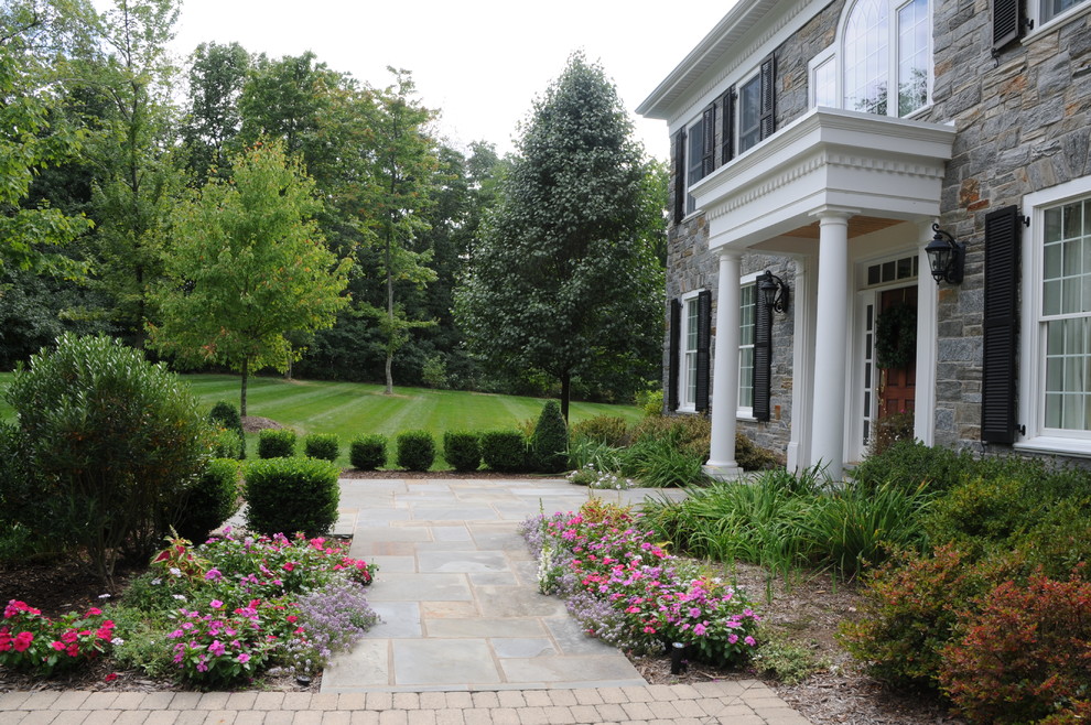 Cette image montre un aménagement d'entrée ou allée de jardin avant traditionnel avec des pavés en pierre naturelle.