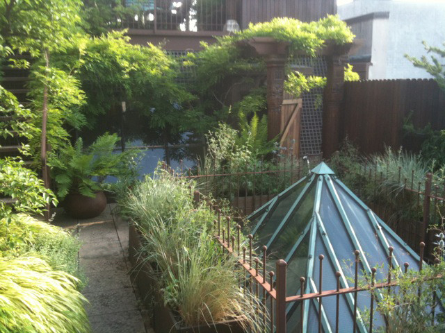 Ispirazione per un ampio giardino eclettico esposto in pieno sole sul tetto in estate con un giardino in vaso, pavimentazioni in pietra naturale e recinzione in metallo
