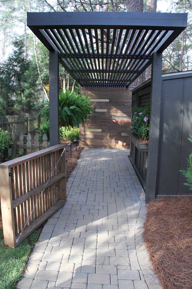 This is an example of a mid-sized contemporary shade backyard concrete paver landscaping in Atlanta.