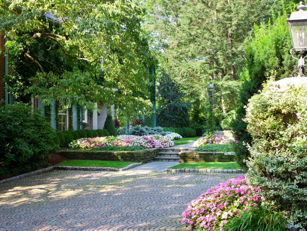 Diseño de jardín clásico grande en patio delantero con exposición parcial al sol y adoquines de hormigón