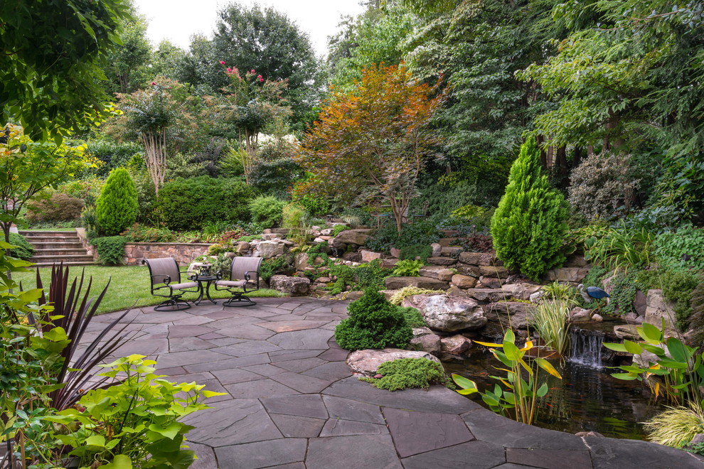Inspiration for a large traditional partial sun front yard stone landscaping in DC Metro.