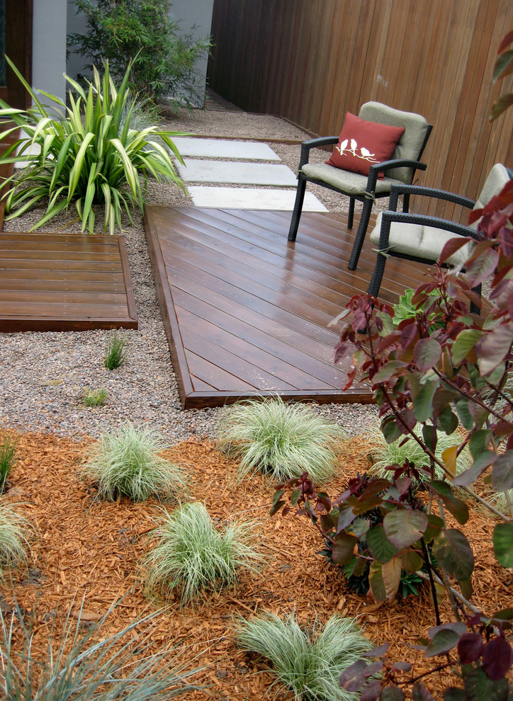 Пример оригинального дизайна: маленький солнечный засухоустойчивый сад на переднем дворе в современном стиле с растениями в контейнерах и хорошей освещенностью для на участке и в саду