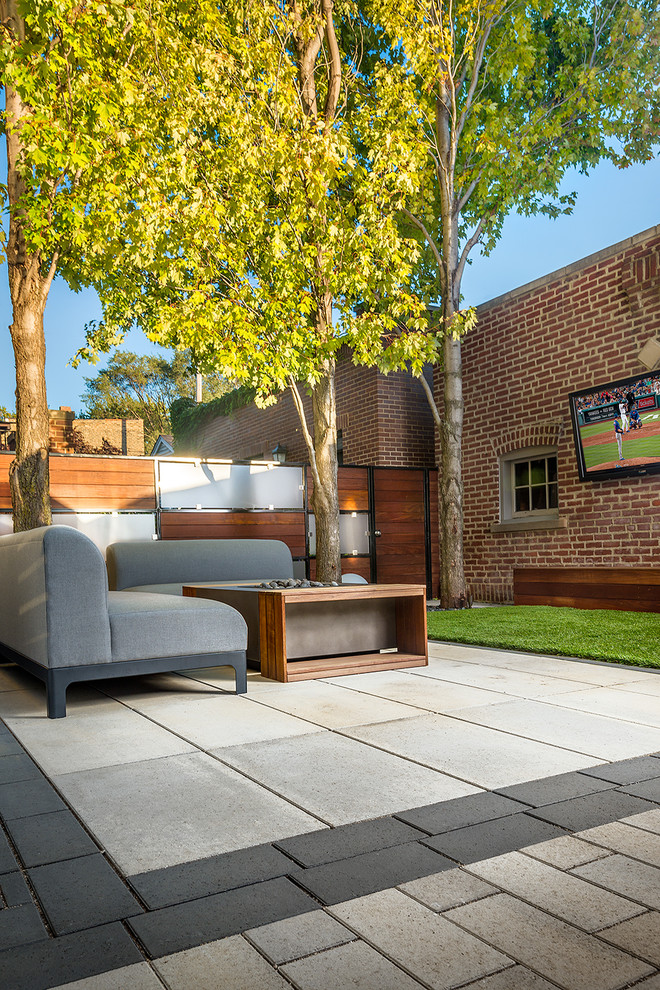 This is an example of a contemporary backyard concrete paver landscaping in Chicago with a fire pit.