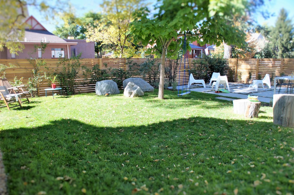 Exempel på en mellanstor modern bakgård i full sol, med naturstensplattor
