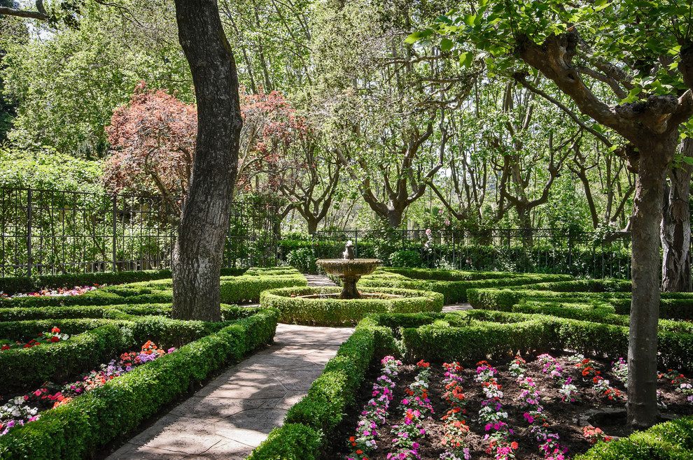 Idée de décoration pour un grand jardin à la française arrière tradition avec une exposition partiellement ombragée.