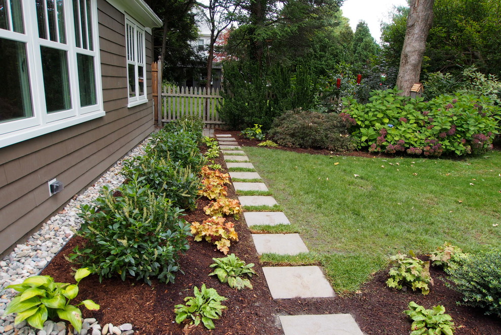 Medium sized classic front partial sun garden for spring in Providence with natural stone paving.