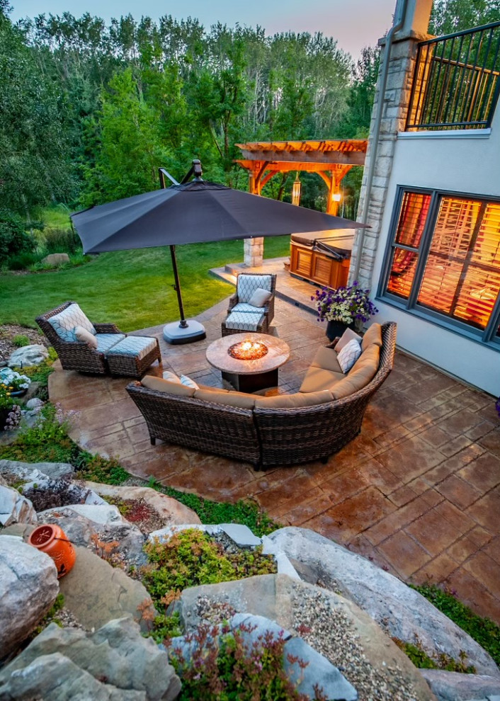 Inspiration for a mid-sized craftsman partial sun backyard concrete paver landscaping in Calgary with a fireplace for summer.