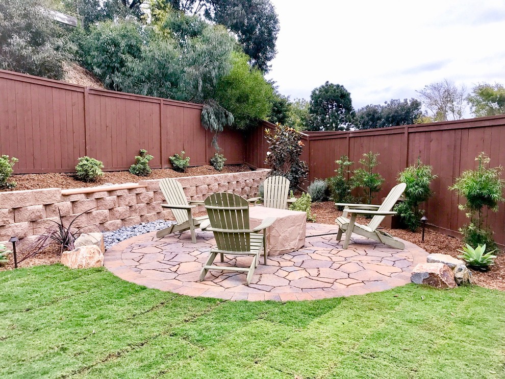 Photo of a mid-sized modern drought-tolerant and full sun backyard brick and wood fence landscaping in San Diego with a fire pit for winter.