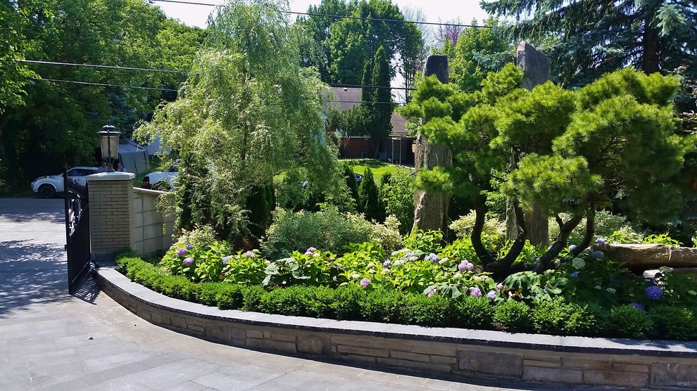 На фото: садовый фонтан на переднем дворе в стиле модернизм с подъездной дорогой