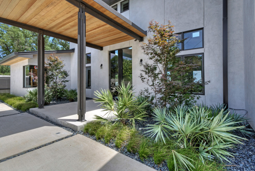 Immagine di un ampio giardino xeriscape design esposto in pieno sole davanti casa in primavera con un giardino in vaso e pavimentazioni in pietra naturale