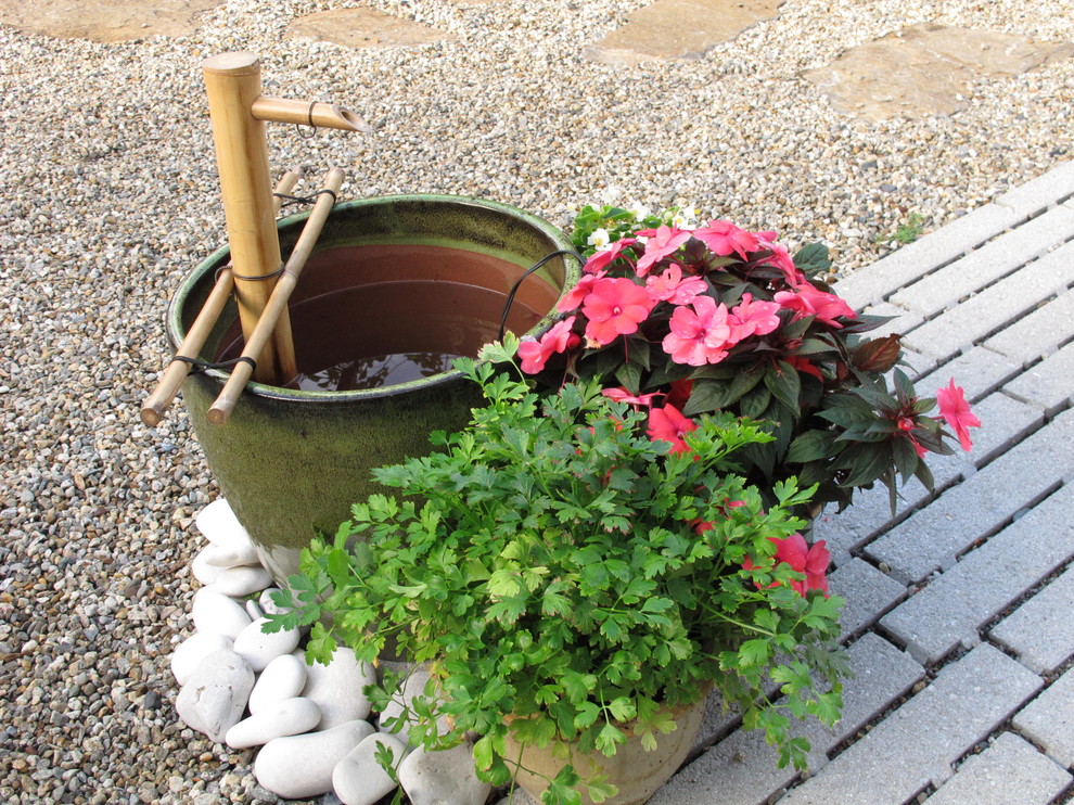 Idee per un piccolo giardino chic esposto in pieno sole dietro casa con fontane e ghiaia