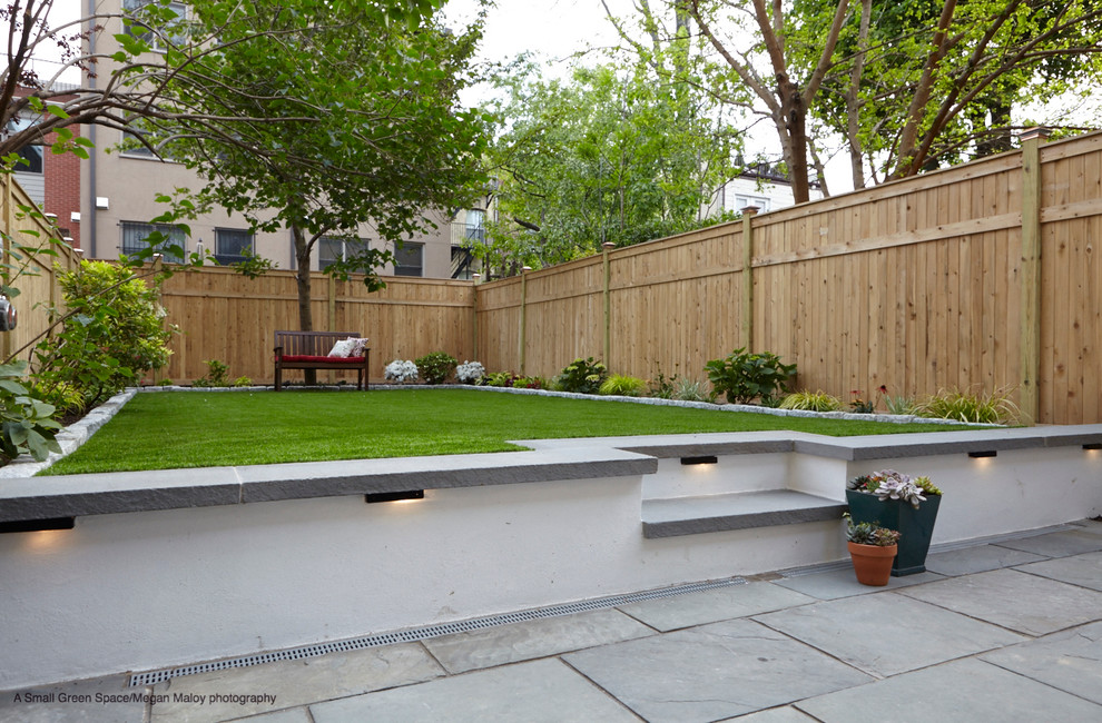 Cette image montre un petit jardin arrière minimaliste avec un mur de soutènement, une exposition partiellement ombragée et des pavés en pierre naturelle.