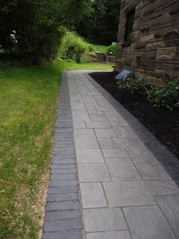 This is an example of a small classic side partial sun garden in Other with concrete paving.