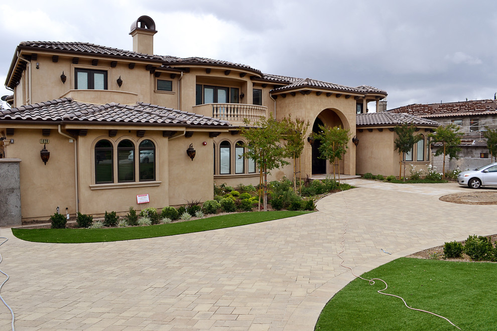 This is an example of a large mediterranean front driveway garden in Los Angeles with concrete paving.