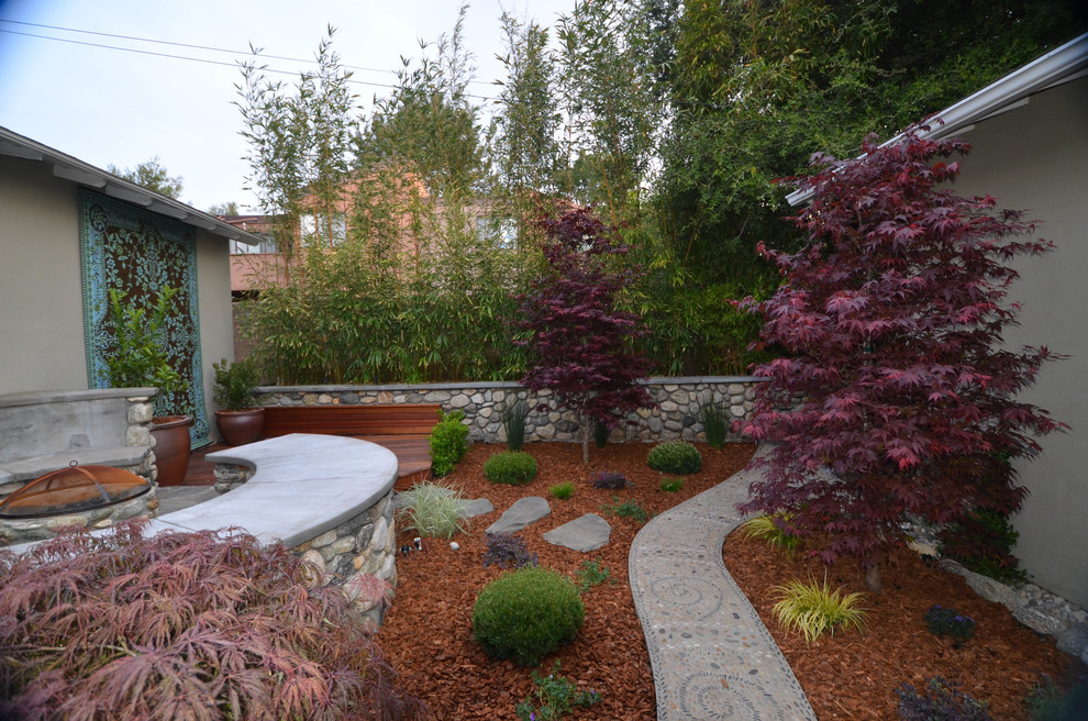 Kleiner, Halbschattiger Asiatischer Garten im Frühling, hinter dem Haus mit Feuerstelle und Natursteinplatten in Los Angeles