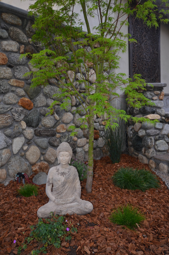 Ejemplo de jardín de estilo zen pequeño en primavera en patio trasero con brasero, exposición parcial al sol y adoquines de piedra natural