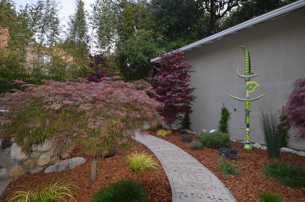 Esempio di un piccolo giardino etnico esposto a mezz'ombra dietro casa in primavera con un focolare e pavimentazioni in pietra naturale