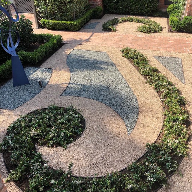 Photo of a small french country rock and full sun courtyard gravel formal garden in Houston.