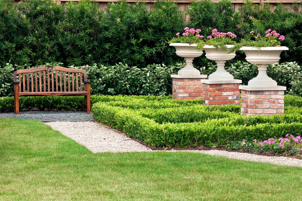 This is an example of a mid-sized traditional full sun backyard gravel formal garden in Houston for spring.