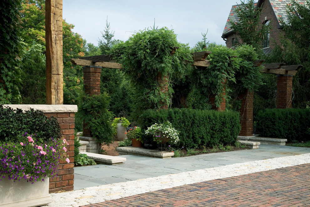 Esempio di un grande giardino classico esposto a mezz'ombra in estate con pavimentazioni in pietra naturale