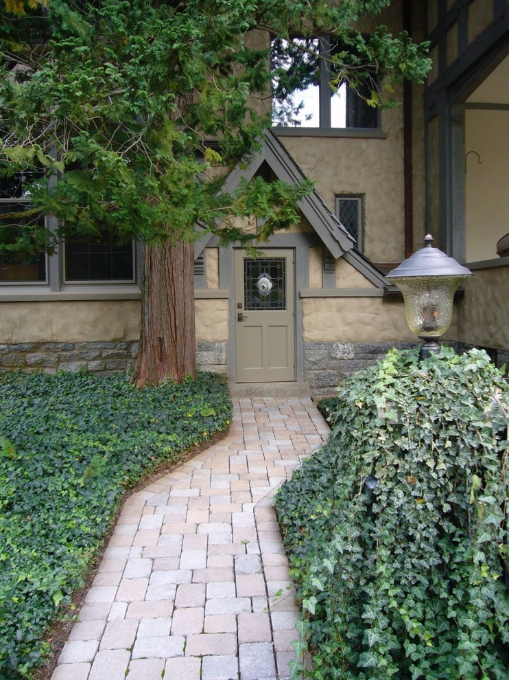Cette photo montre un jardin arrière chic de taille moyenne avec une exposition ensoleillée et des pavés en pierre naturelle.