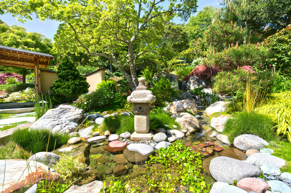 Großer, Halbschattiger Asiatischer Garten im Sommer, hinter dem Haus mit Wasserspiel und Natursteinplatten in San Francisco