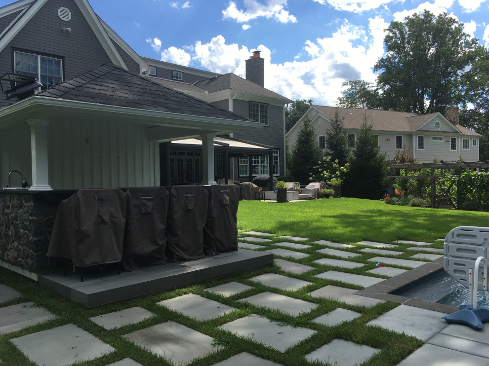 Modelo de jardín actual grande en patio trasero con exposición total al sol y adoquines de piedra natural