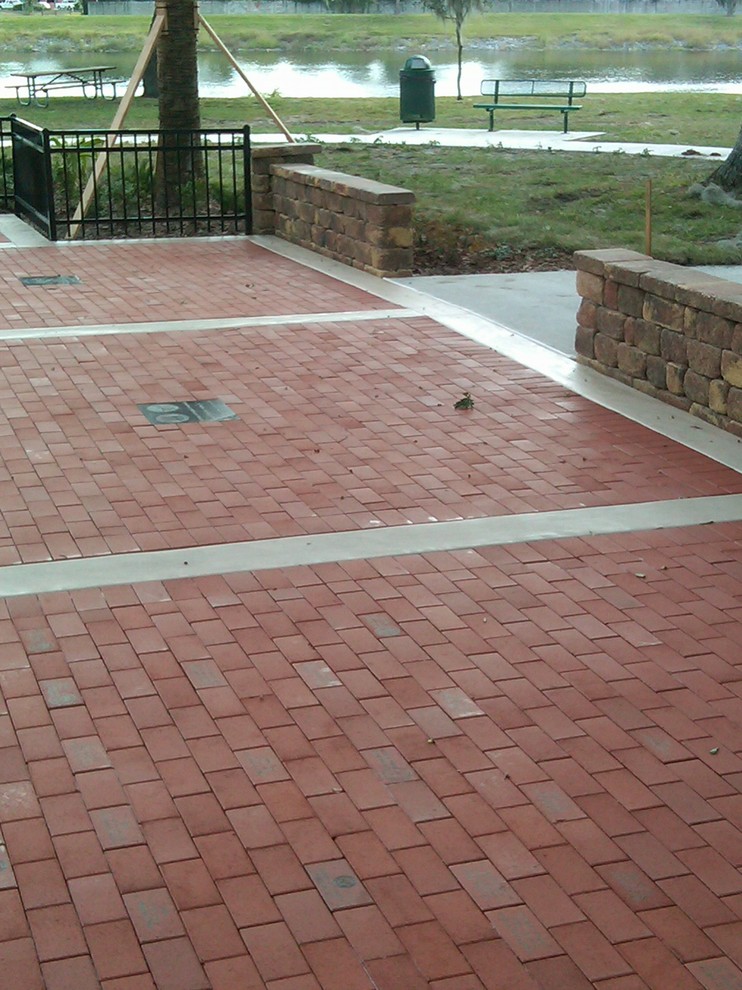 This is an example of a medium sized classic front driveway full sun garden in Tampa with a garden path and brick paving.