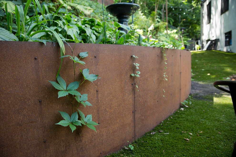 Ispirazione per un giardino minimal esposto in pieno sole dietro casa con un muro di contenimento