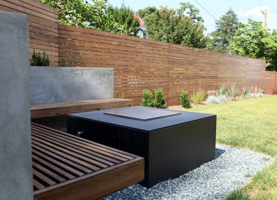 Design ideas for a modern back garden in DC Metro with a fire feature and concrete paving.