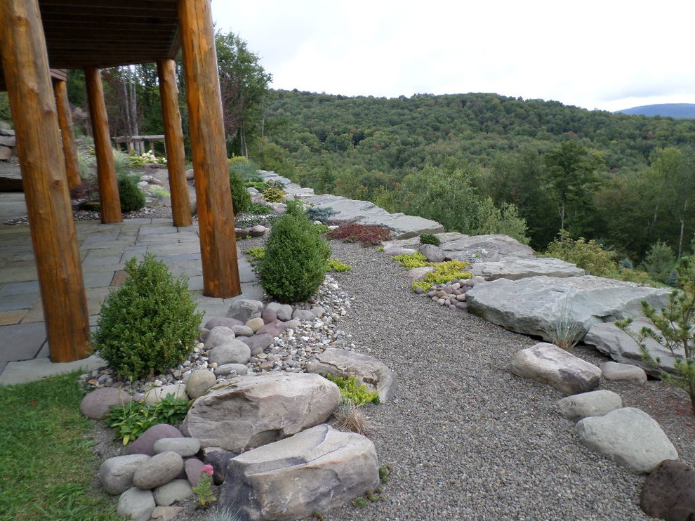 Photo of a large rustic full sun and drought-tolerant backyard gravel garden path in New York.