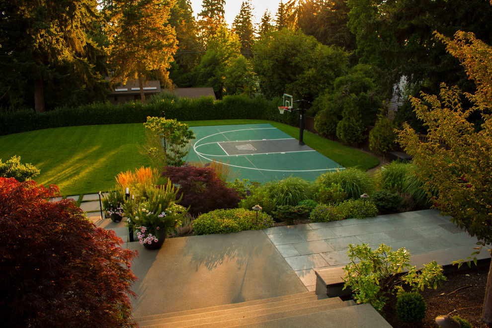 Großer Moderner Garten hinter dem Haus mit Sportplatz, direkter Sonneneinstrahlung, Spielgerät und Betonboden in Seattle