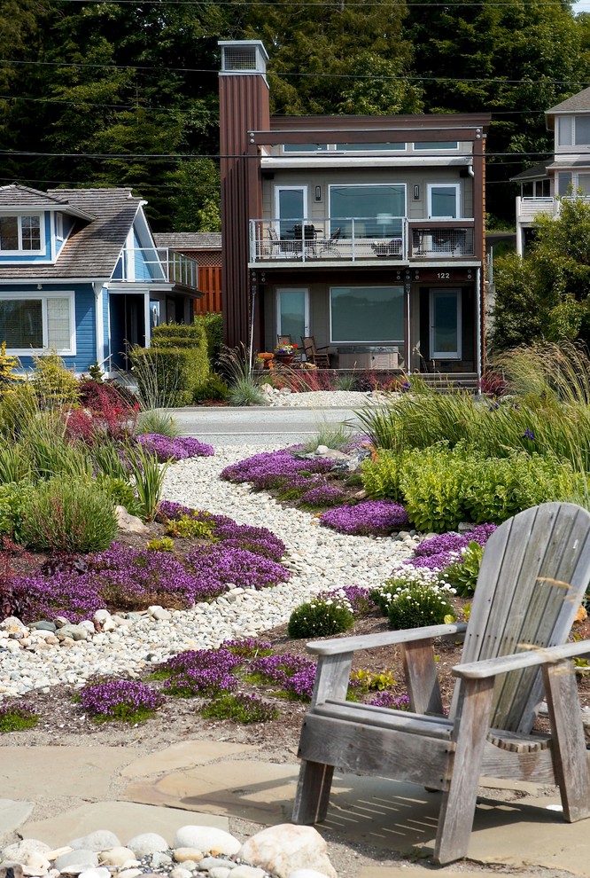 Cette photo montre un jardin à la française avant bord de mer de taille moyenne et l'été avec un foyer extérieur, des pavés en pierre naturelle et une exposition ensoleillée.