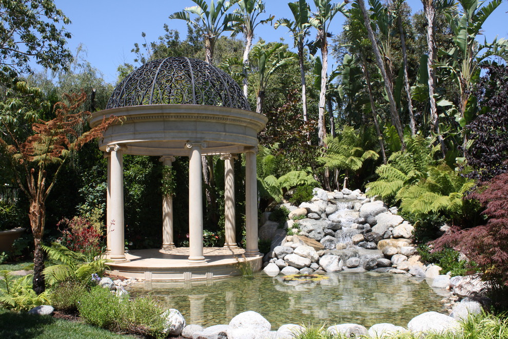 Photo of a classic back partial sun garden in Santa Barbara with natural stone paving and a pond.