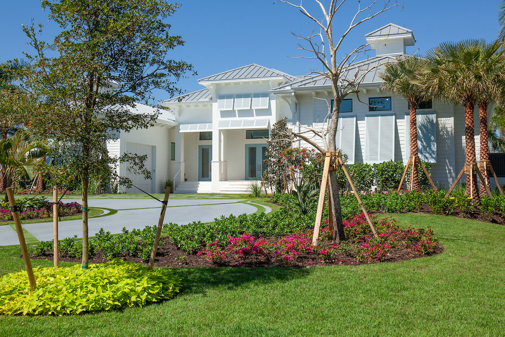 Immagine di un vialetto d'ingresso tropicale esposto in pieno sole di medie dimensioni e davanti casa con un ingresso o sentiero e pavimentazioni in cemento