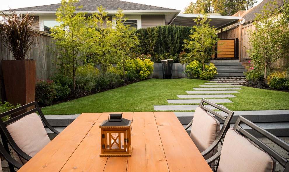 This is an example of a small contemporary back partial sun garden in Vancouver with a garden path and natural stone paving.