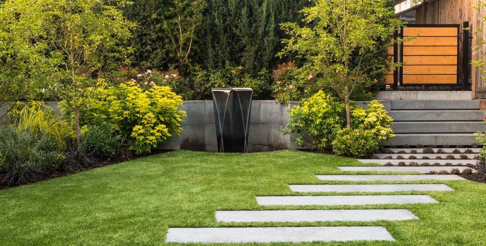 Photo of a small contemporary back partial sun garden in Vancouver with a garden path and natural stone paving.