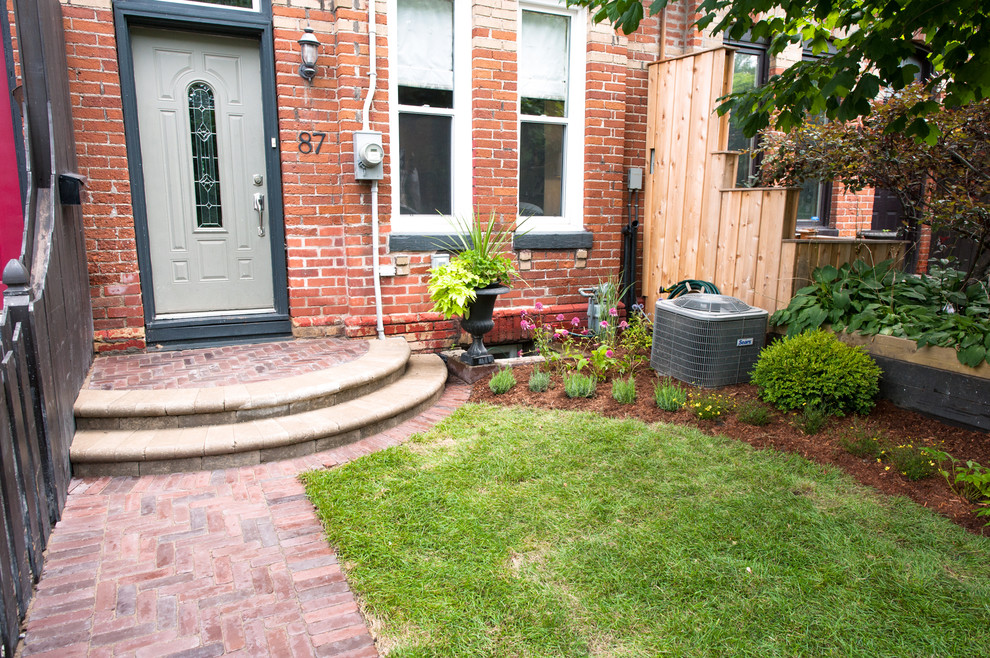 Inspiration for a small classic front formal partial sun garden for spring in Toronto with brick paving and a garden path.