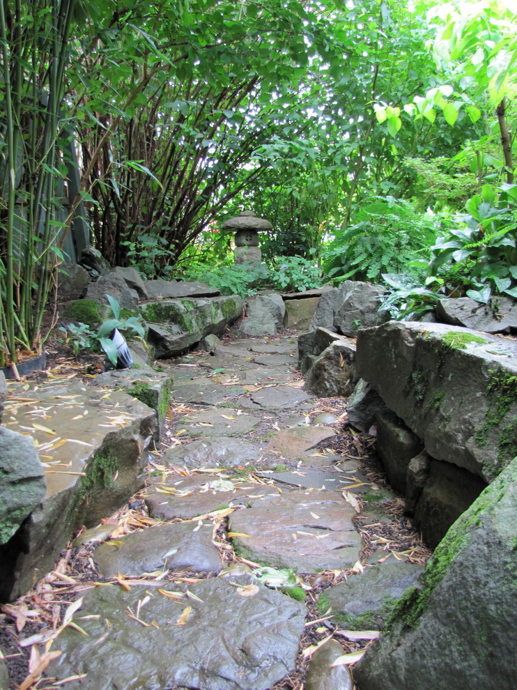 Medium sized eclectic back formal garden in New York with a garden path and natural stone paving.