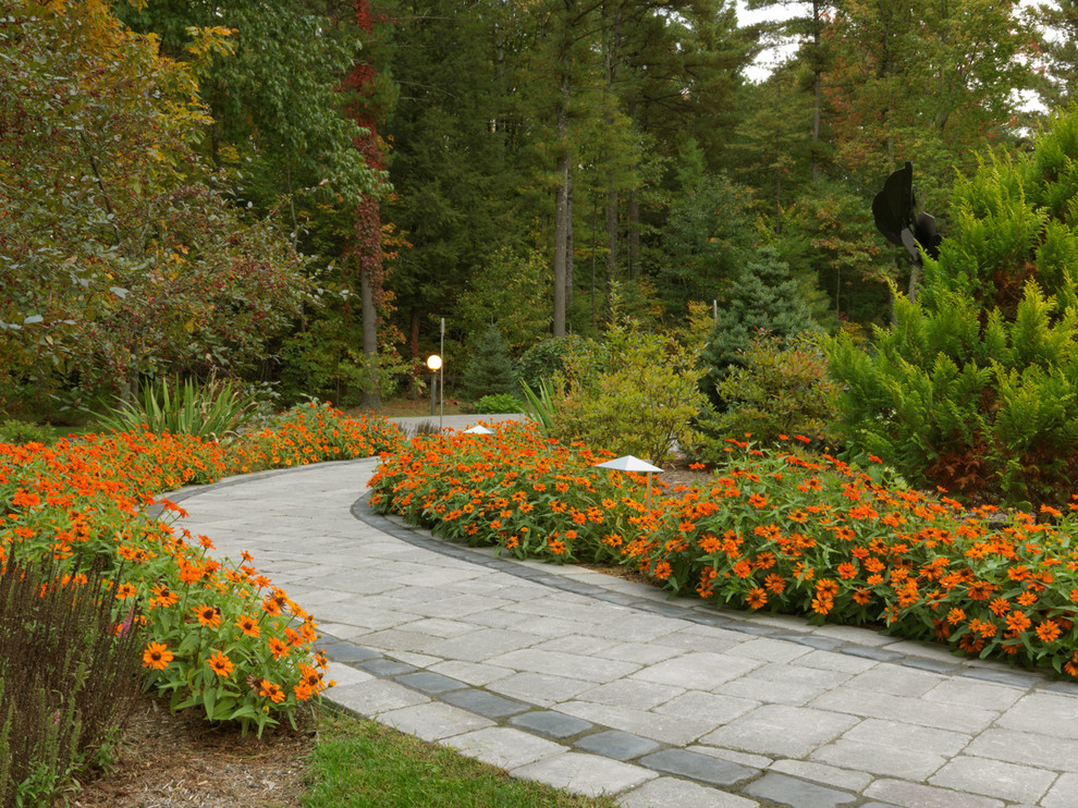 Exemple d'un jardin avant chic avec une exposition ensoleillée, des pavés en béton et un massif de fleurs.