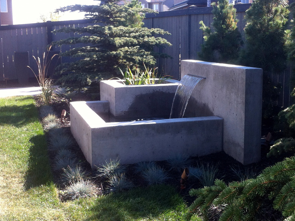 Großer Moderner Garten hinter dem Haus mit Wasserspiel und Betonboden in Vancouver