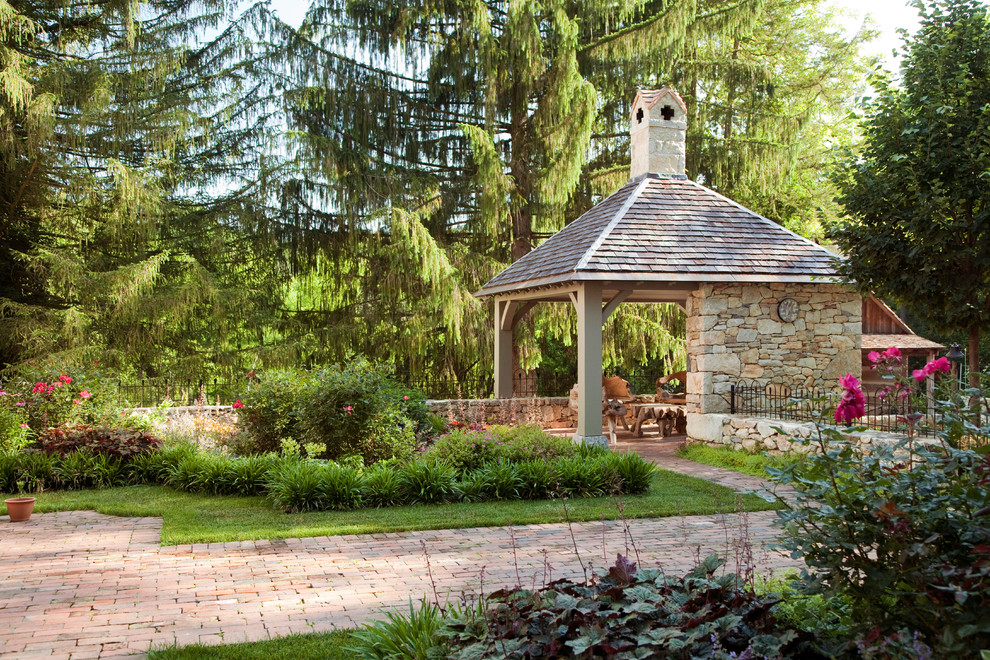 Imagen de camino de jardín clásico en patio trasero con jardín francés y adoquines de ladrillo