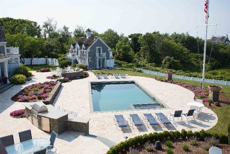 Expansive nautical back full sun garden for summer in Boston with a fire feature and natural stone paving.